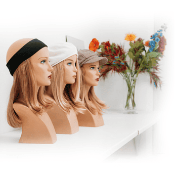 Mannequin heads with different hairstyles and hats at Salon 2 Go for hair styling practice and display.