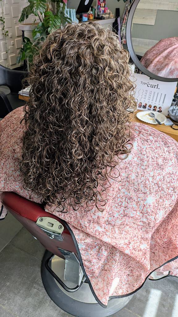 Professioneel gekruld haar in salonstoel, klaar voor behandeling.